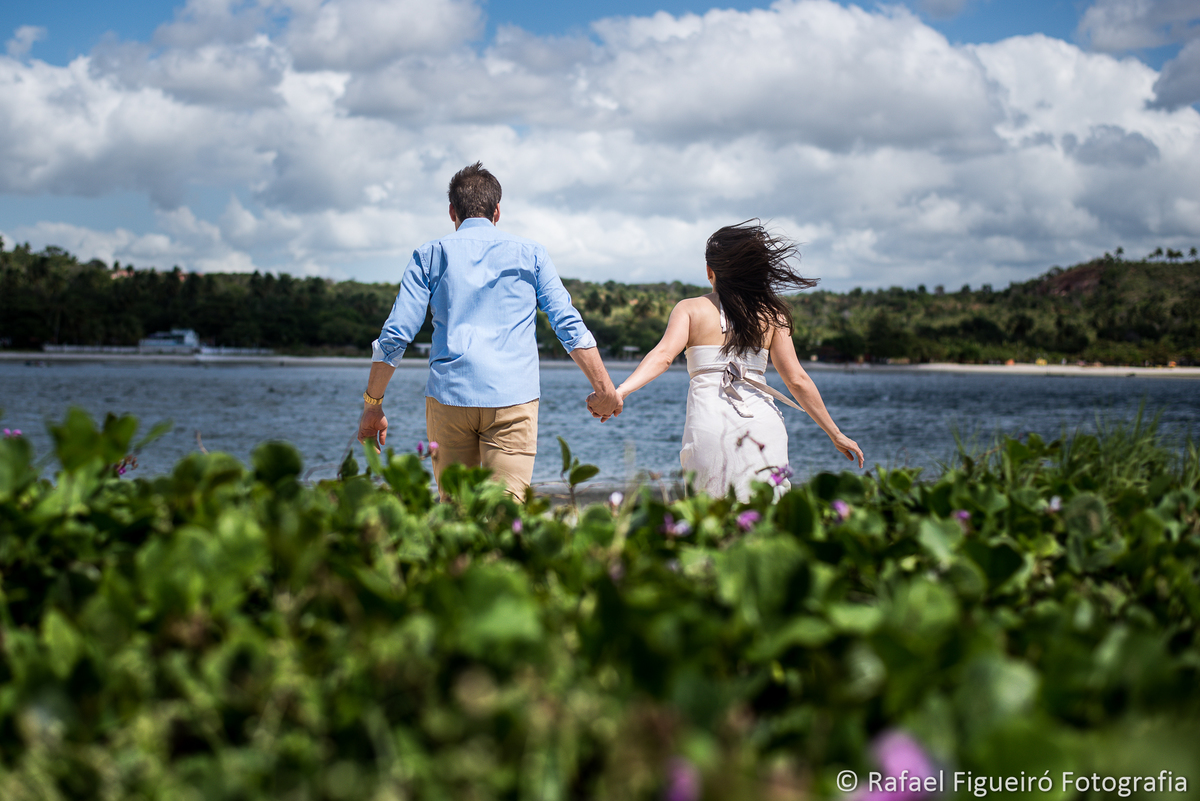 casal maos dadas correndo direção do rio rimbó nuvens céu azul
