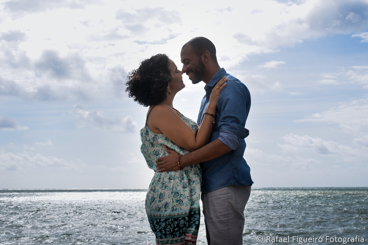 casal namorando em pé ceu azul mar horizonte
