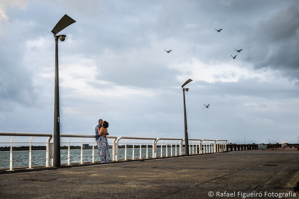 cais do recife antigo grades brancas casal encostado abraçando pombos voando nuvens