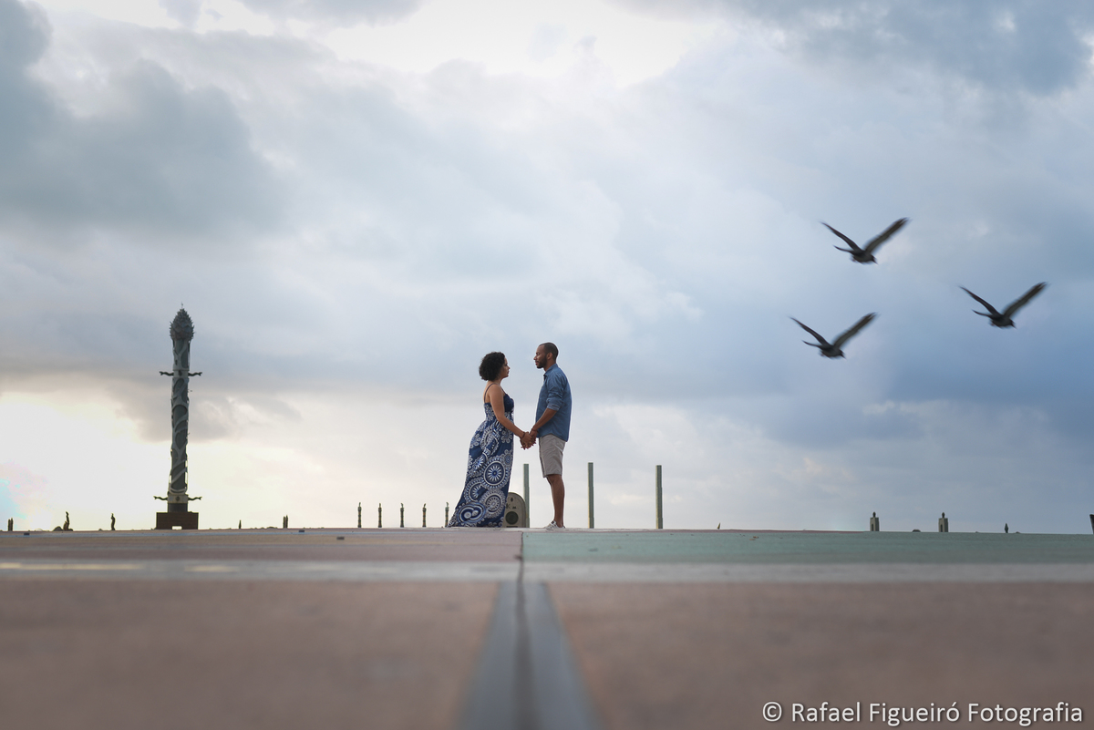 marco zero casal em pe se olhando pombos voando nuvens ceu recife antigo