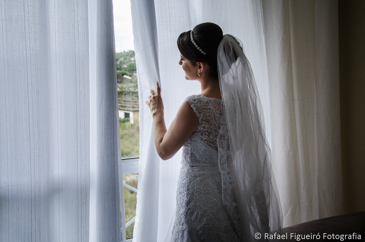 noiva espiando pela cortina branca vestido véu