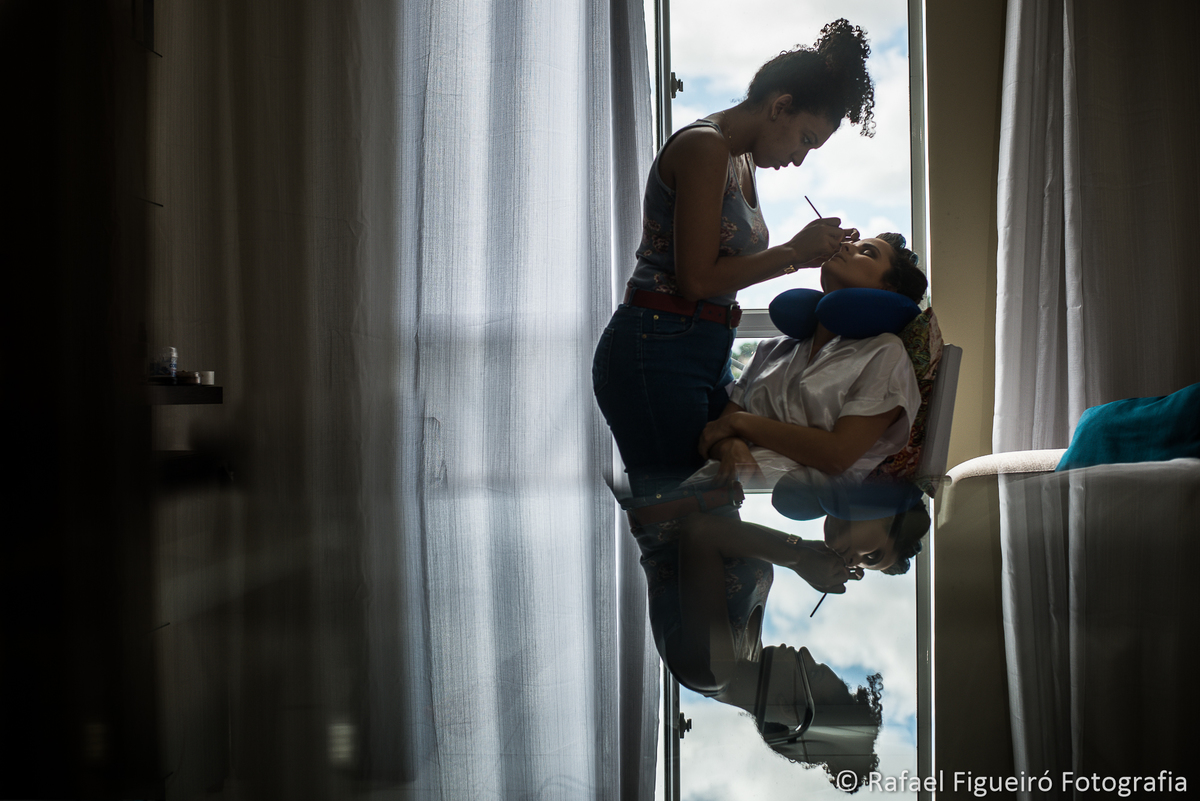 noiva sendo maquiada reflexo mesa de vidro contra luz janela