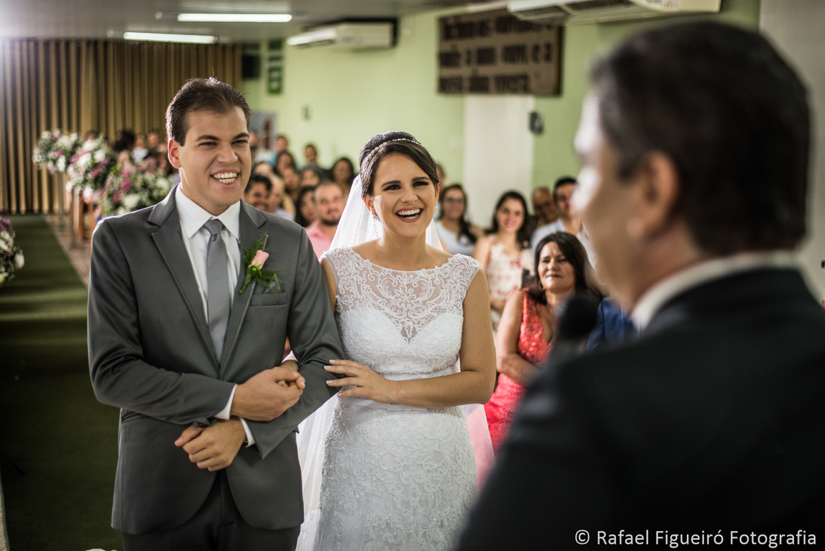 noivos no altar sorrindo para pastor