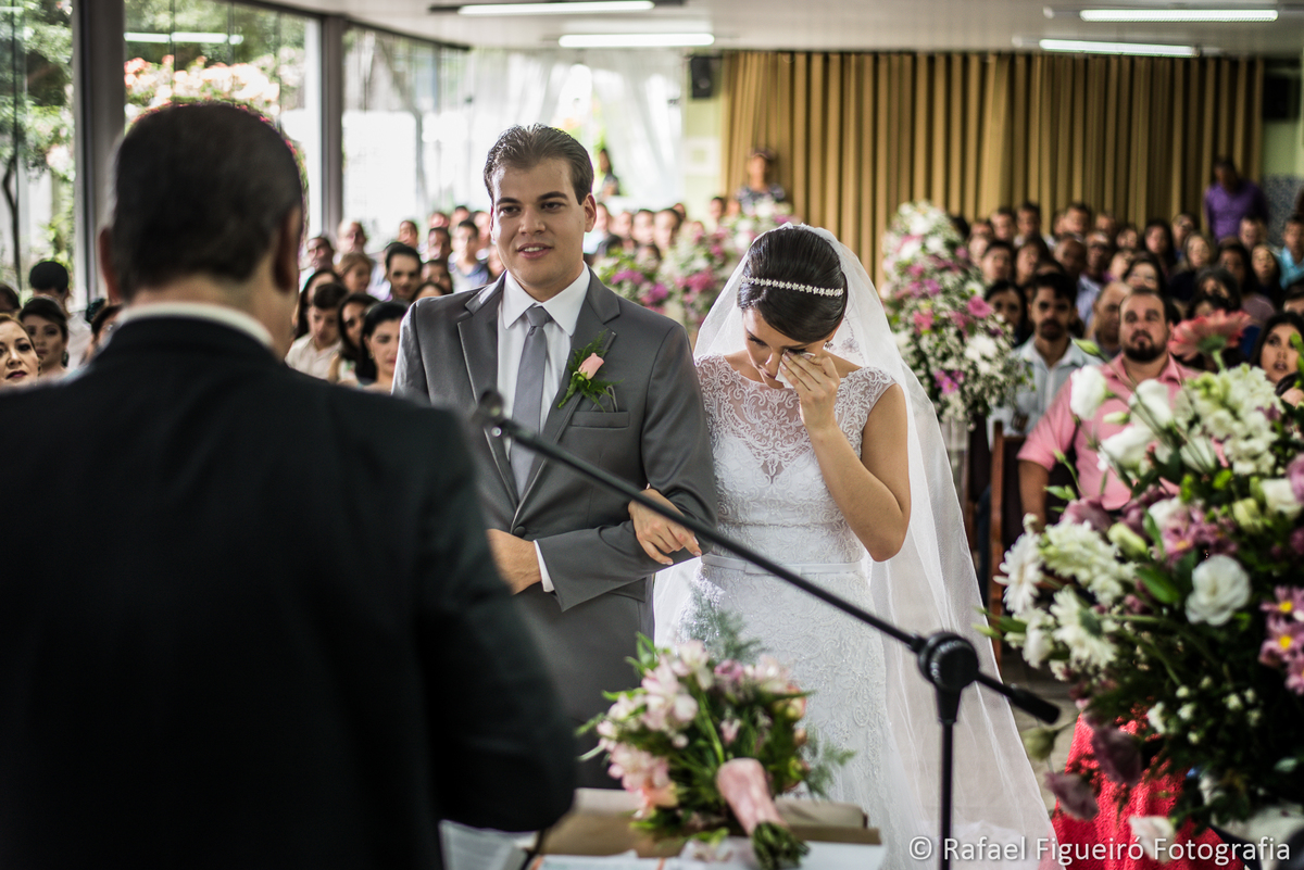 noiva enxugando lágrima no altar pastor de costas emocionada