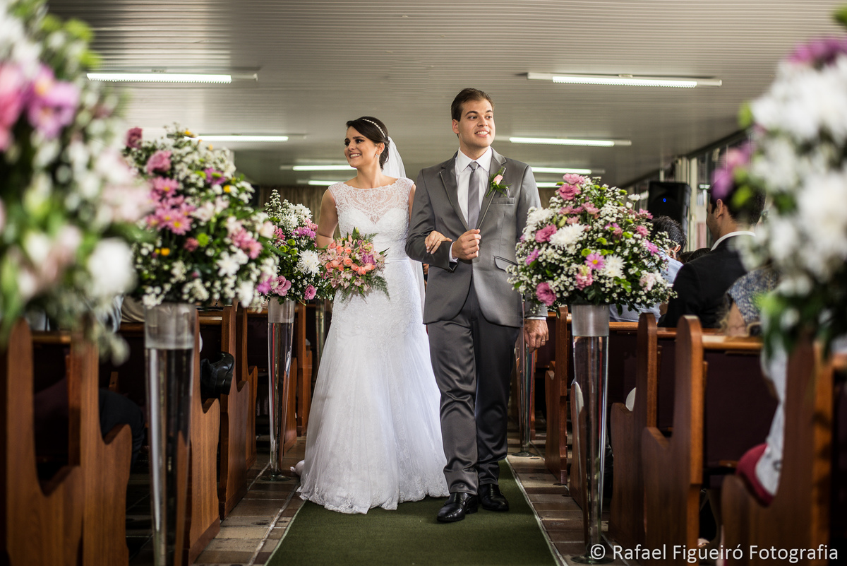 saida dos noivos casal andando em direção a saida da igreja sorrindo