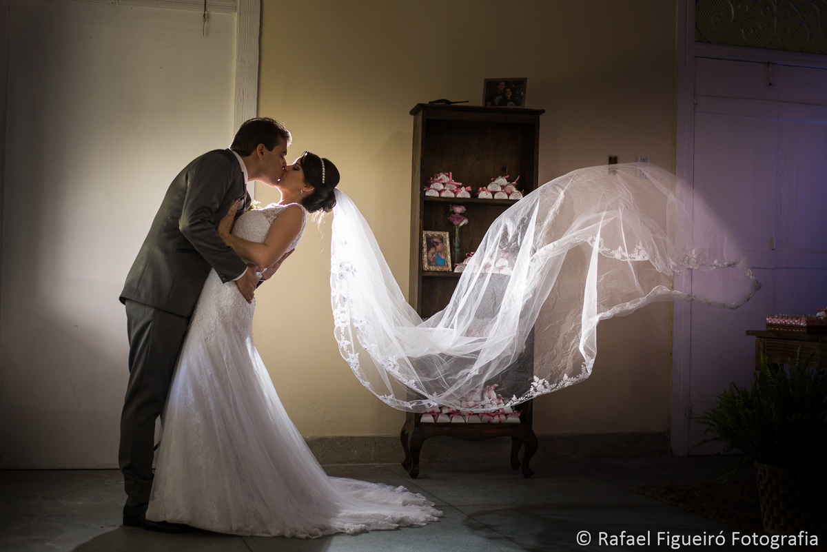 noivo beijando noiva véu voando