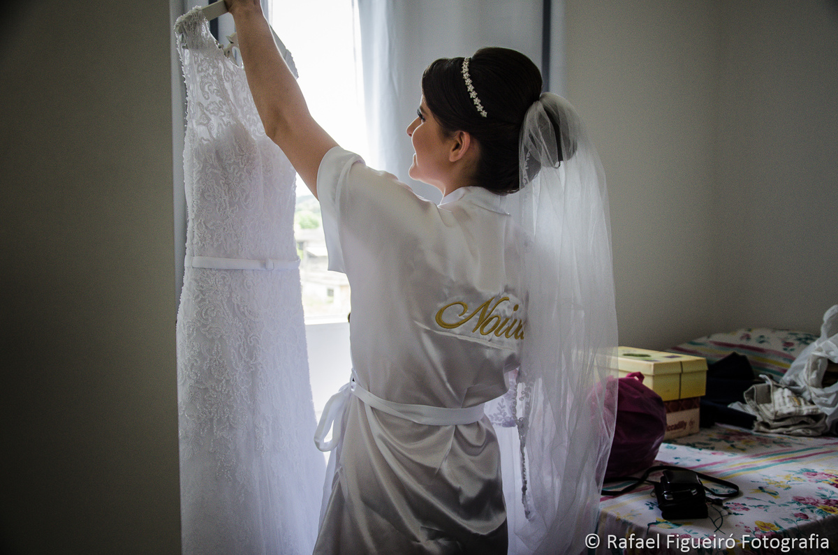 noiva segurando cabide do vestido de casamento hobby noiva
