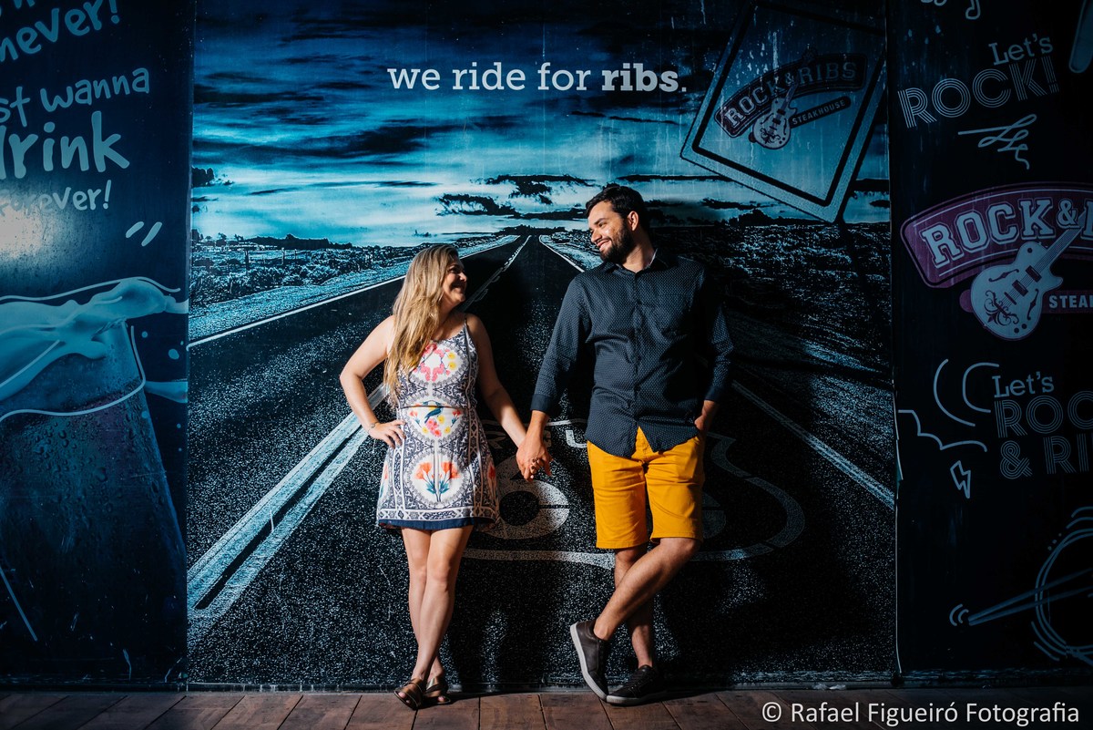 casal de maos dadas encostados em frente a painel rua rock ribs recife antigo azul