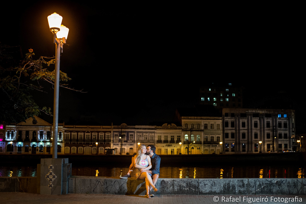 rua da aurora ao fundo casaroes iluminados rio capibaribe reflexo agua noite casal namorando poste antigo luz abarelada ambar