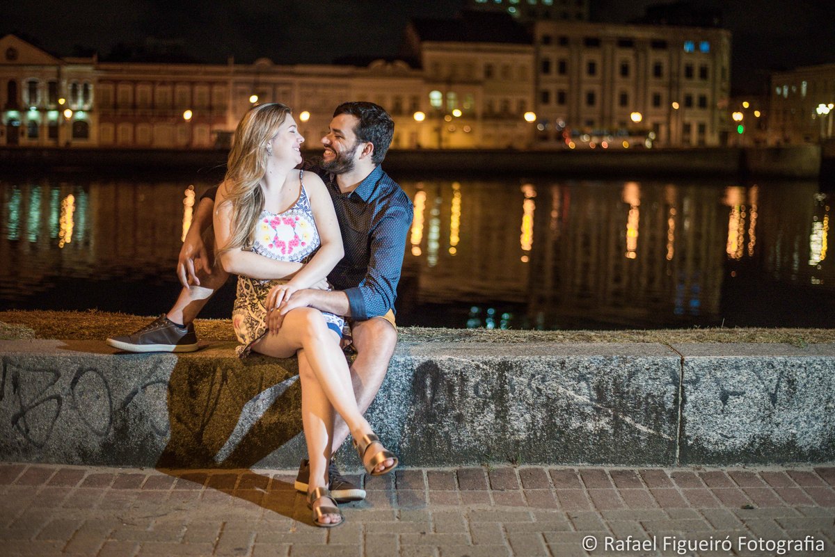 rua da aurora ao fundo casaroes iluminados rio capibaribe reflexo agua noite casal namorando