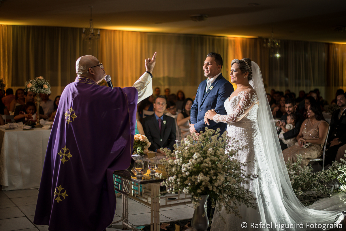 bispo de costas apontando Deus casal noivos sorrindo cerimonia religiosa 