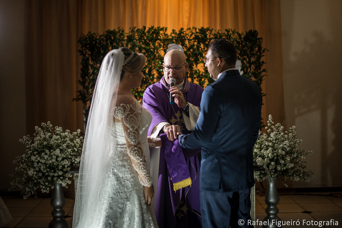 sacramento do casamento bispo de frente noivos de costas luz lateral casamento