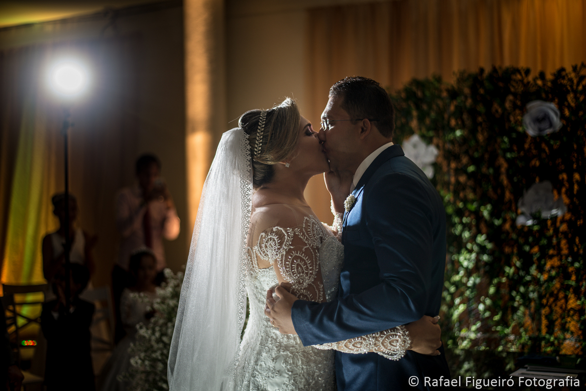 beijo dos noivos cerimônia religiosa contra luz