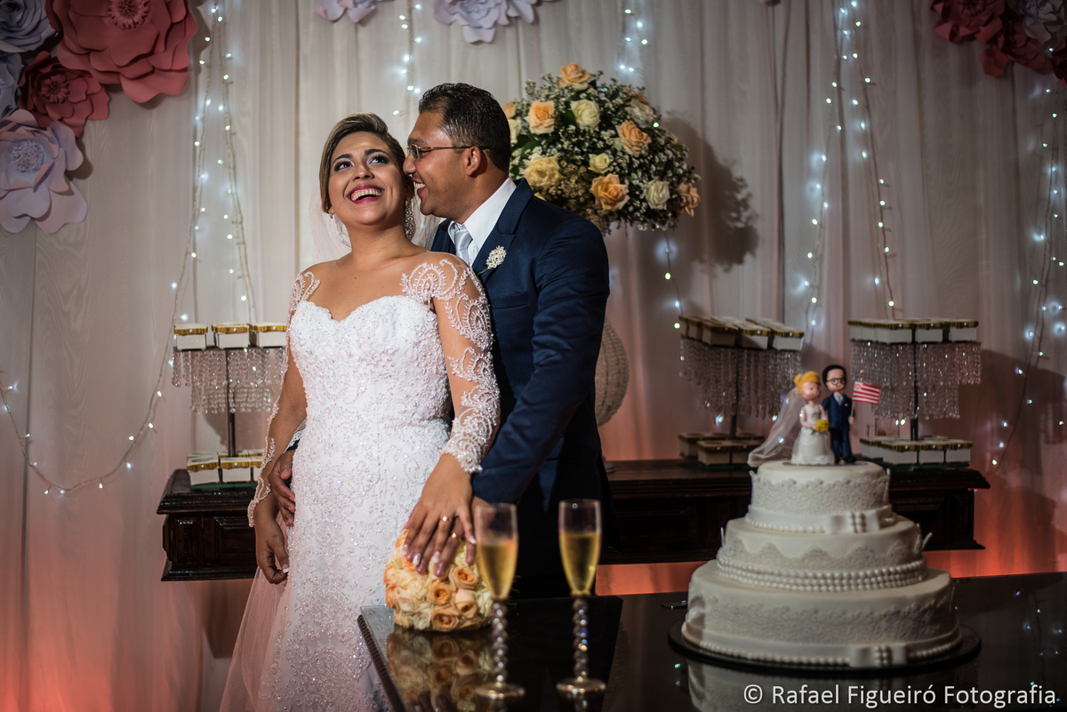noivo cochichando no ovido da noiva sorrindo no bolo taças brinde champagne casamento 