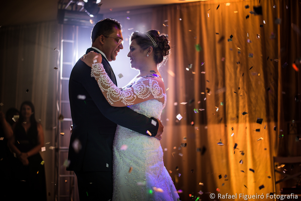 noivos dançando valsa chuva de prata papel picado contra luz