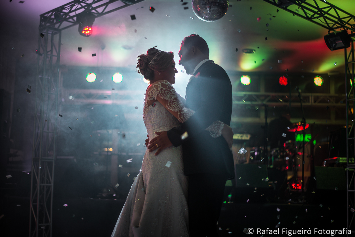 noivos dançando valsa chuva de prata papel picado contra luz fumaça