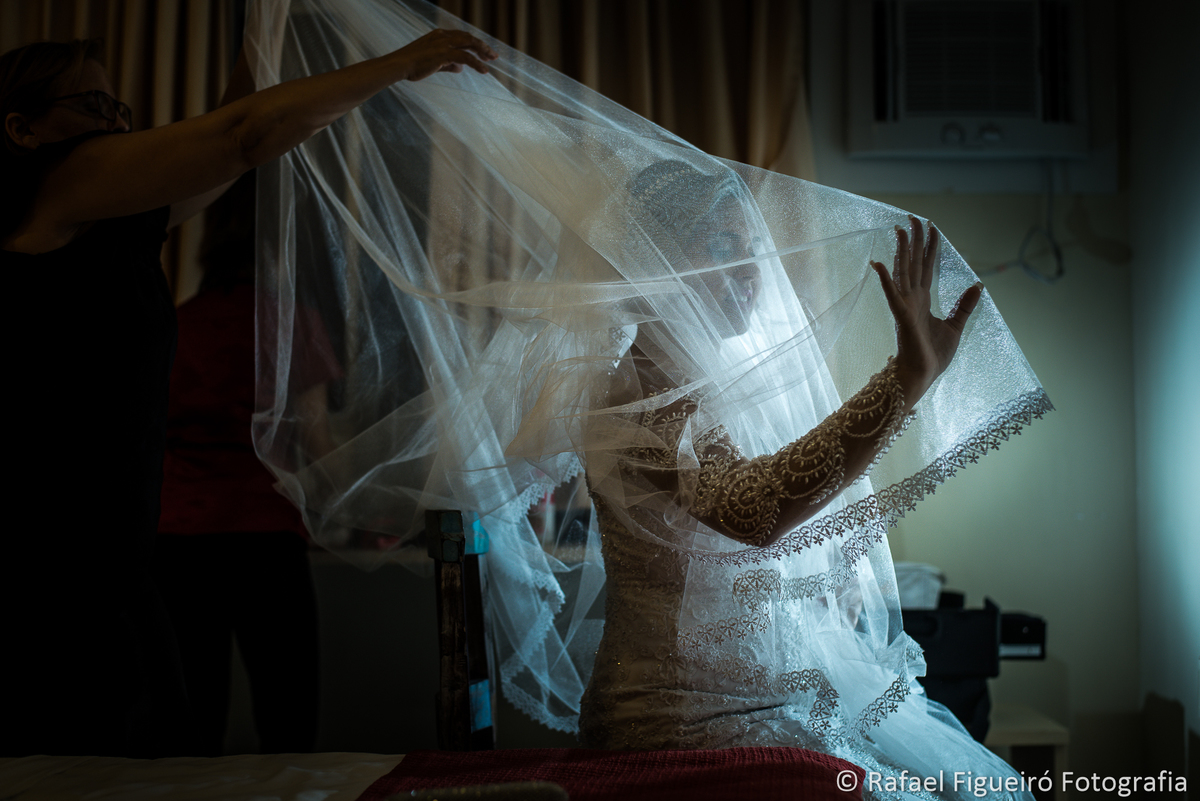 veu de noiva colocando mãos levantadas, contra luz making of da noiva