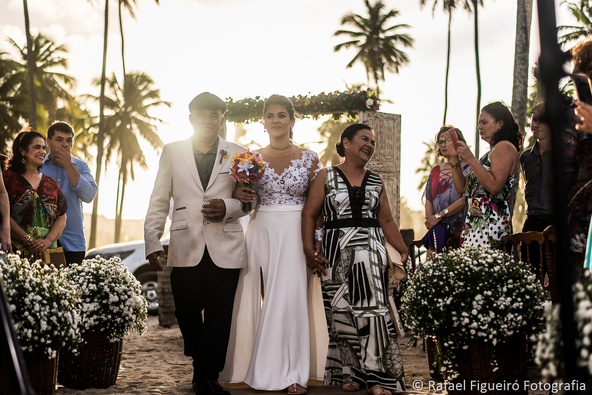 entrada da noiva pai e mae sol contra luz entardecer convidados celulares sorriso felicidade amor casamento 
