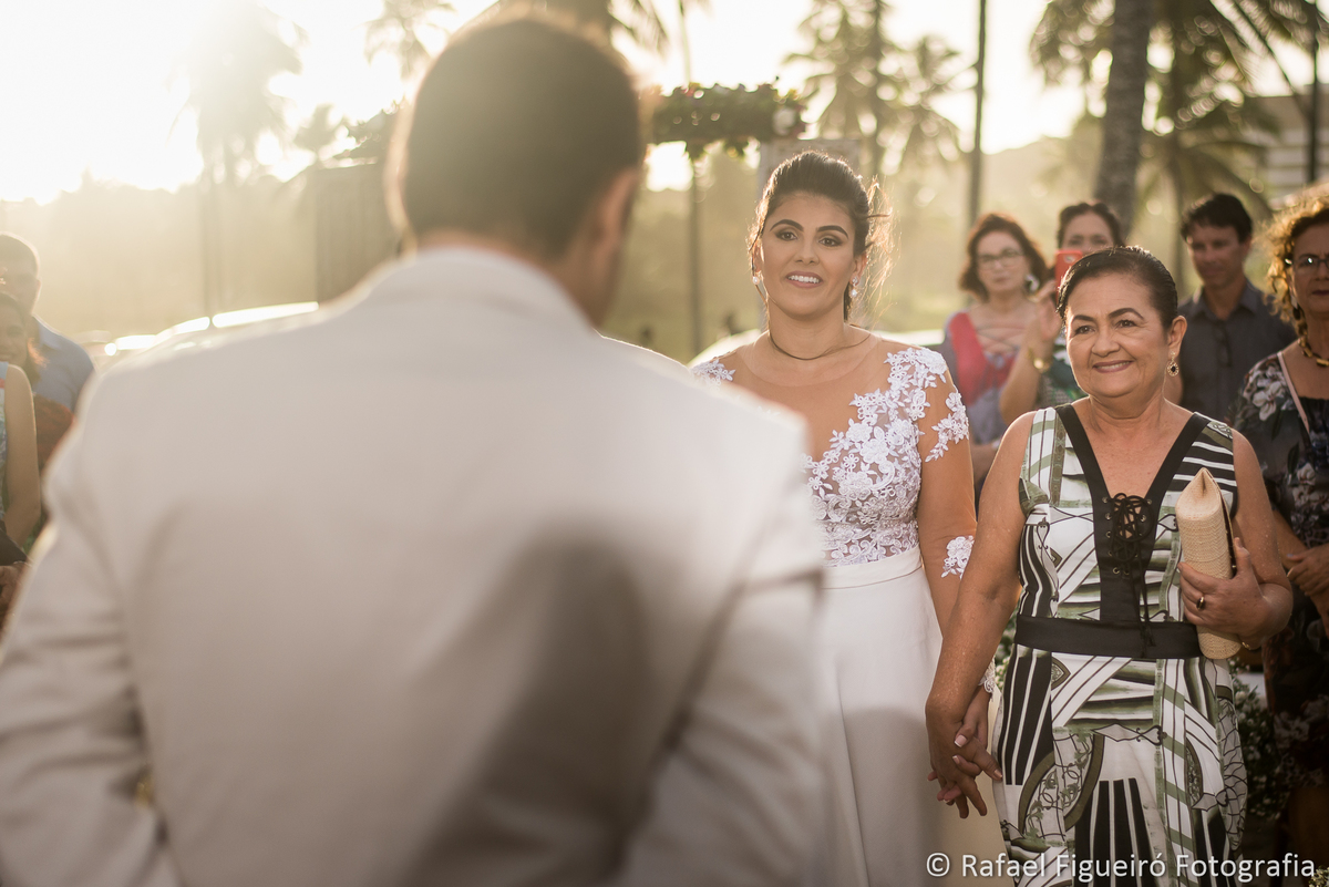 noiva e mae olhando para o noivo sorriso felicidade amor sol entardecer coqueiros praia do paiva reserva da coruja