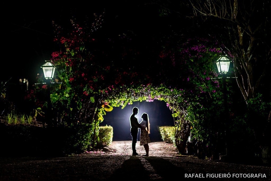 Casal contra luz carramanchão portal roseiras luminarias escuro amor 