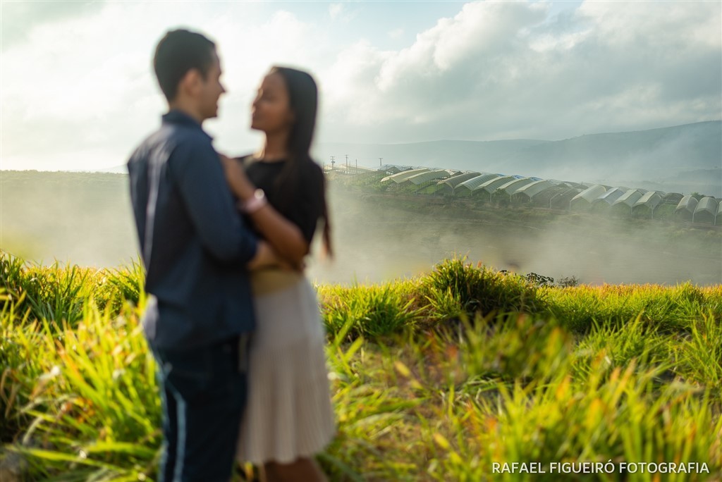 casal namorando desfoque mato alto campo estufa orquidário ao fundo paisagem vista