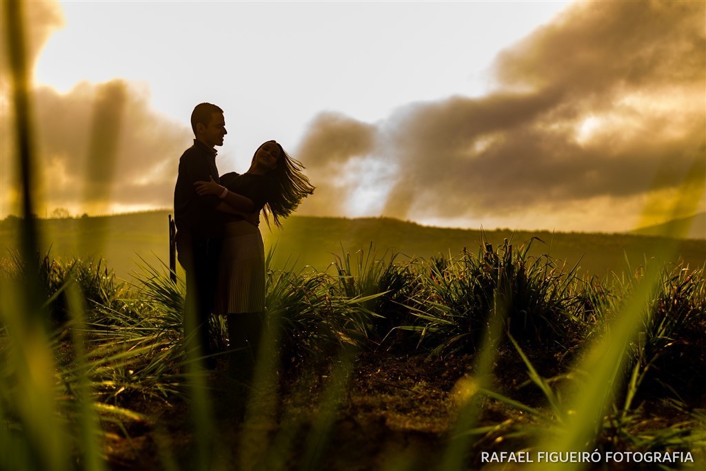casal silhoueta contra luz mato gramado amarelo ceu dramatico