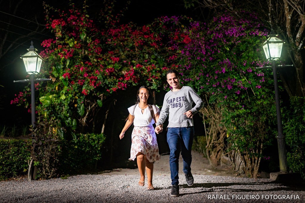 Casal correndo carramanchão portal roseiras luminarias escuro amor 
