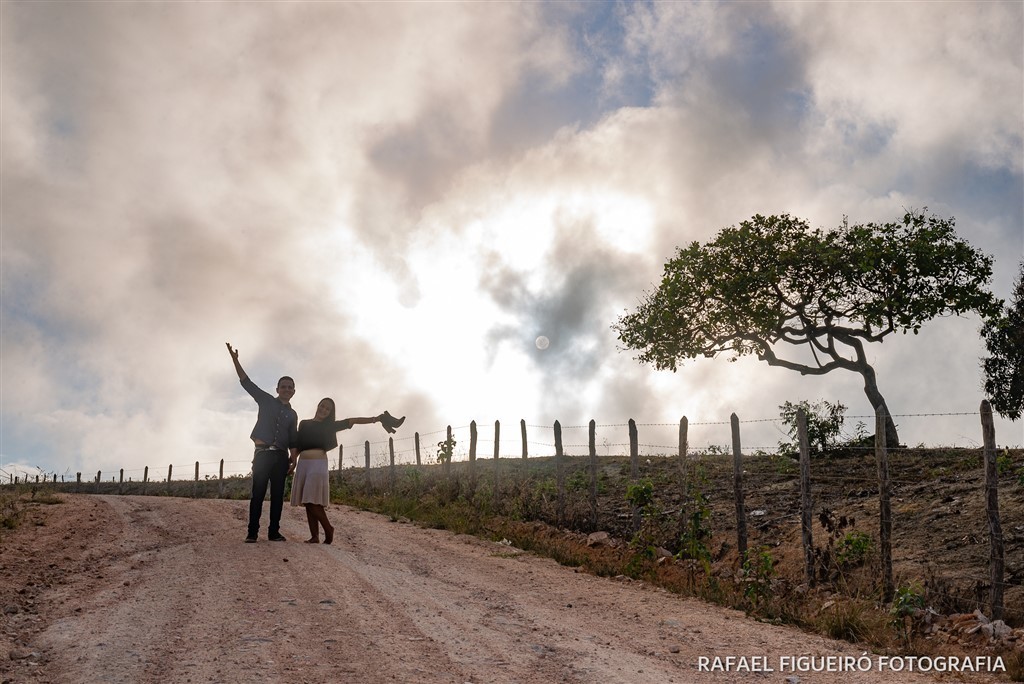 casal acenando contra luz sol encoberto claro escuro estrada terra barro chao batido chã-grande