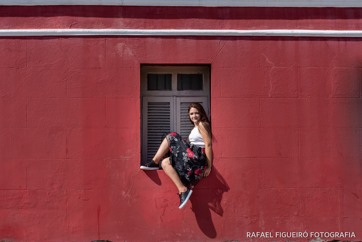 modelo debutante sentada janela madeira branca parede vermelha fundo recife antigo antiga estação