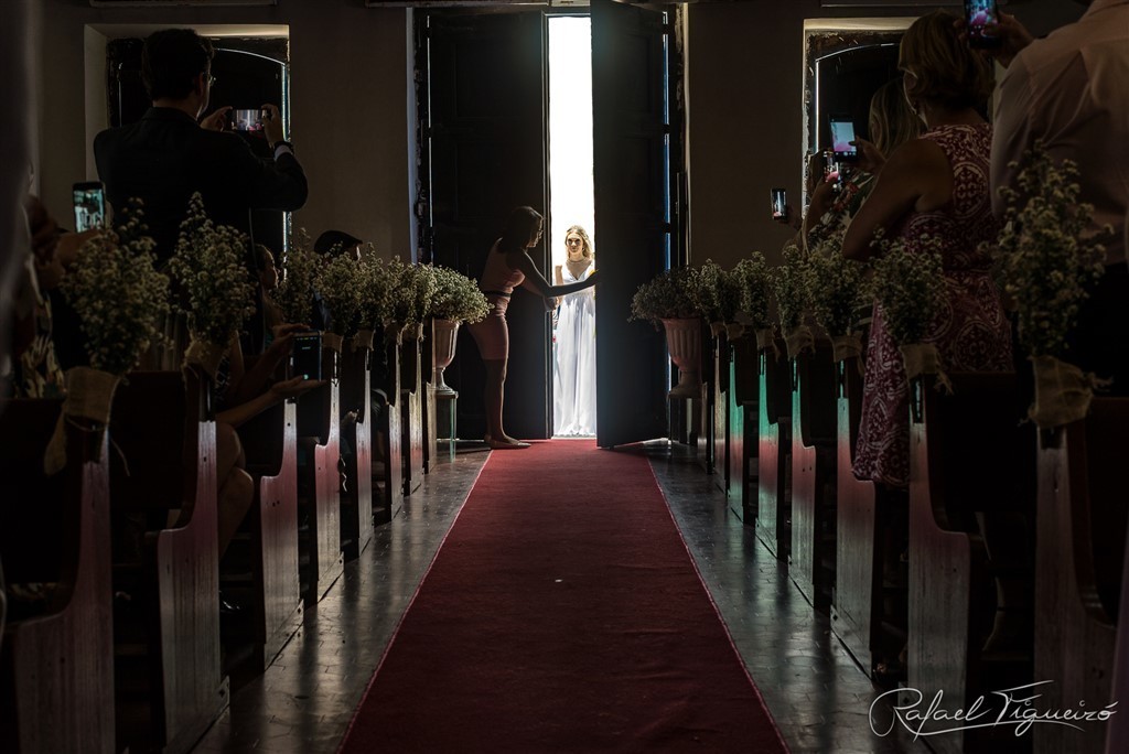 casamento igreja nossa senhora de boa viagem melhor fotógrafo de casamento recife rafael figueiró porta igreja abrindo escuro contra luz noiva elegante espiando entrando