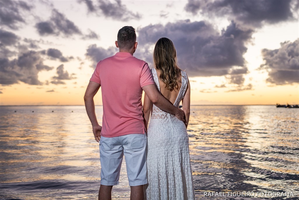 casal admirando nascer do sol costas