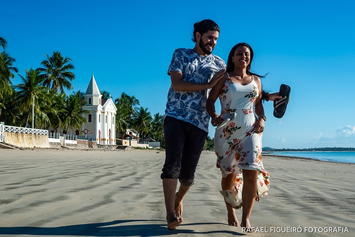 Ensaio Pre-Wedding do simpático casal Duda e Lucas, realizado na Praia de Tamandaré-PE Sul de Pernambuco, pelas redondezas da Igreja de São Perdo. casal correndo chinelo na mao