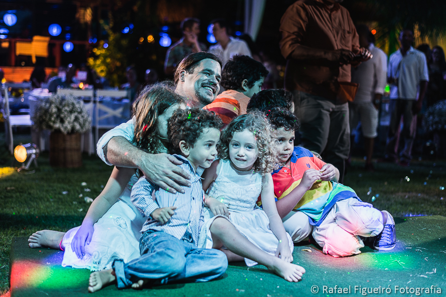 Noivo sentado no chão rodeado de crianças lindas recebendo homenagem da noiva  fotografado por Rafael Figueiró fotógrafo de casamentos em Recife-PE pernambuco