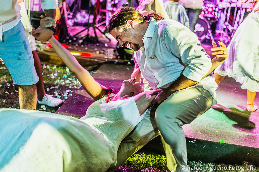 noiva depois de tomar algumas é segurada pelo noivo para não se espatifar no chão na festa de casamento  fotografado por Rafael Figueiró fotógrafo de casamentos em Recife-PE pernambuco