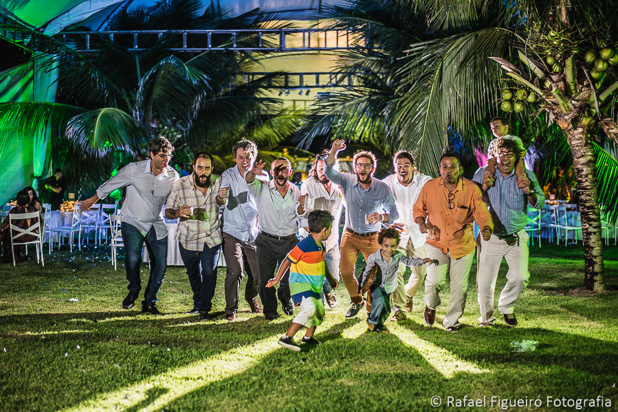 Noivo e amigos correm com copos de bebida na mão em festa de casamento no serrambí resort  fotografado por Rafael Figueiró fotógrafo de casamentos em Recife-PE pernambuco