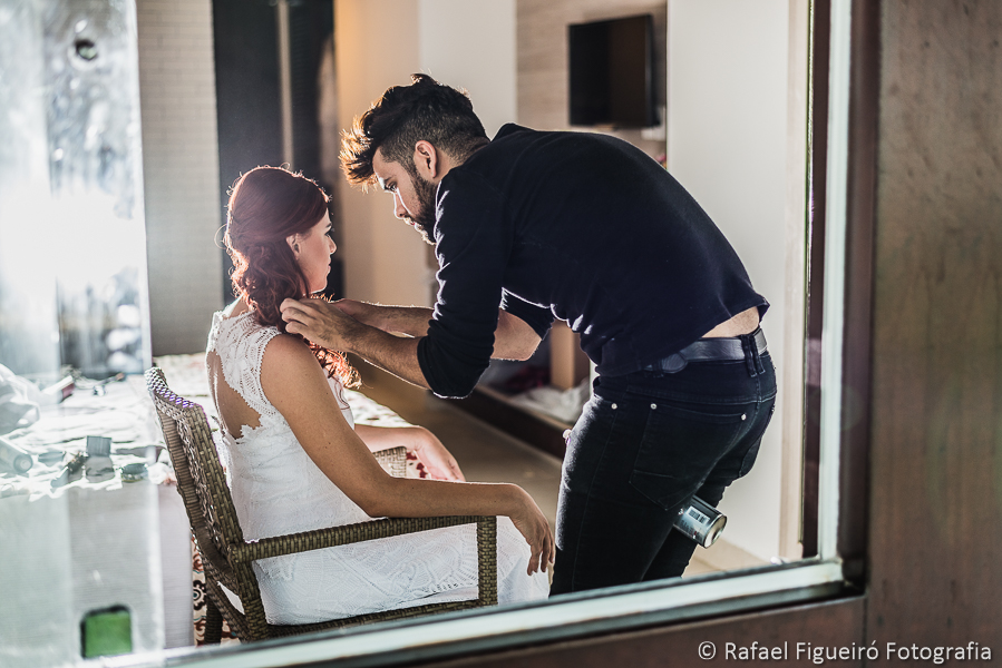 maquiador segurando o tubo de laque no meio das pernas iluminação diferenciada fotografado por Rafael Figueiró fotógrafo de casamentos em Recife-PE pernambuco