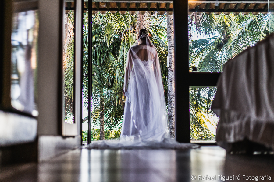 noiva pronta na porta do quarto com coqueiros ao fundo fotografado por Rafael Figueiró fotógrafo de casamentos em Recife-PE pernambuco