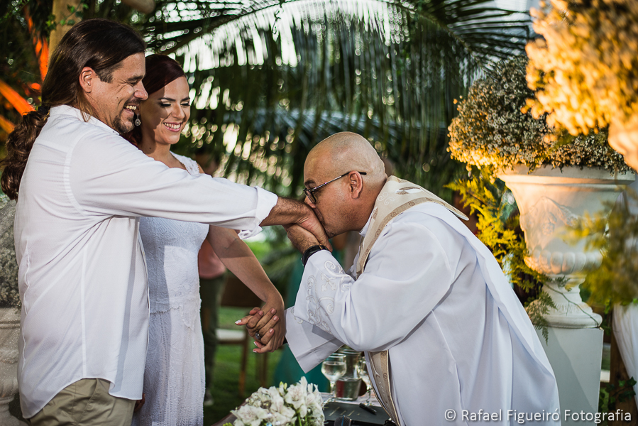 Reverendo Markos Leal beijando as mãos dos noivos felizes ao chegarem no altar fotografado por Rafael Figueiró fotógrafo de casamentos em Recife-PE pernambuco