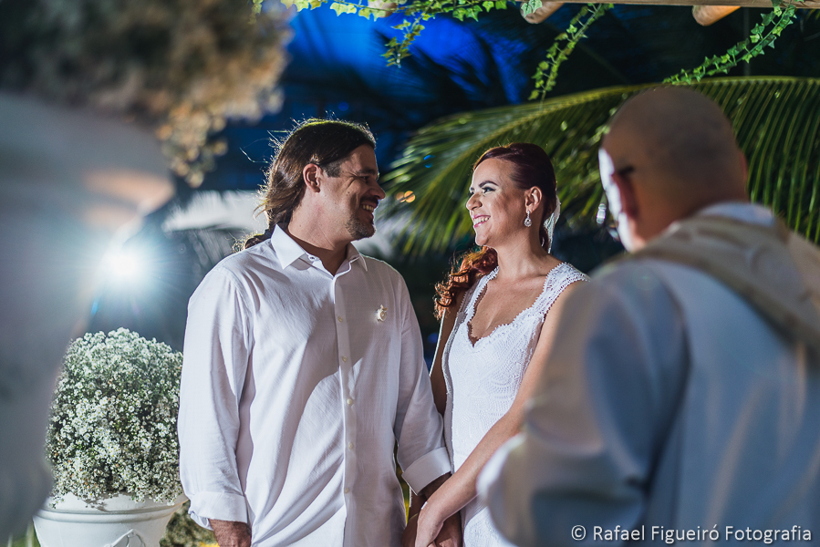 troca de olhares e sorrisos apaixonados entre noivo e noiva em meio aos coqueiros da praia do serrambí resort fotografado por Rafael Figueiró fotógrafo de casamentos em Recife-PE pernambuco