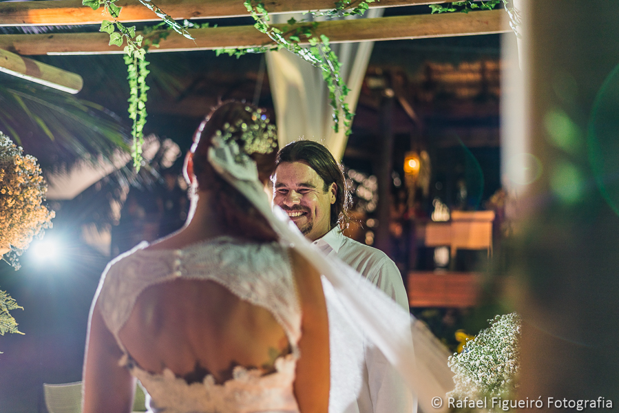 troca de olhares e sorrisos apaixonados entre noivo e noiva em meio aos coqueiros da praia do serrambí resort fotografado por Rafael Figueiró fotógrafo de casamentos em Recife-PE pernambuco