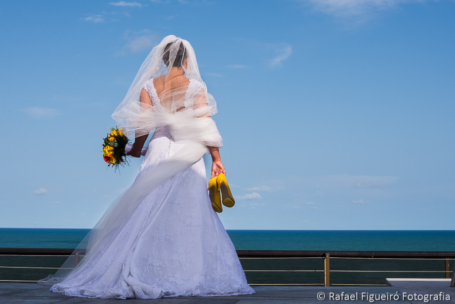 Noiva de costas em um dekc de madeira com mar infinito ao fundo fotografado por Rafael Figueiró melhor fotógrafo de casamentos de Recife-PE