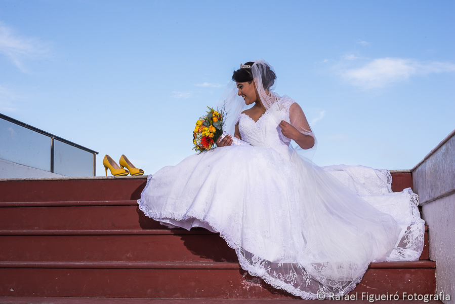 noiva sentada na escada olhando para seus sapatos amarelos fotografado por Rafael Figueiró melhor fotógrafo de casamentos de Recife-PE
