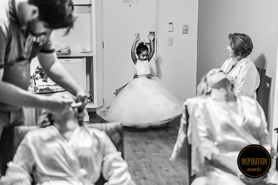 Foto Premiada pelo Inspiration Photographers daminha rodando feliz com seu vestido enquanto mãe noiva e avó se arrumam rafael figueiró melhor fotógrafo de casamento em recife-pe