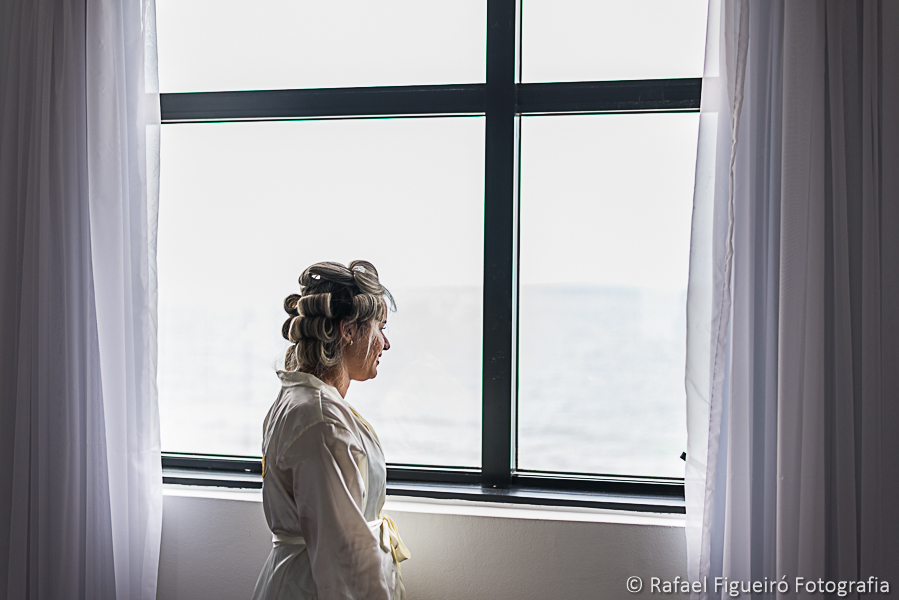 Noiva serena olhando pela janela o mar de uma nova vida fotografado por rafael figueiró melhor fotógrafo de casamentos em recife