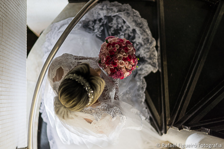 Detalhe do bouquet da noiva subindo escada caracol fotografado por Rafael Figueiró fotógrafo melhor de casamentos em Recife-PE