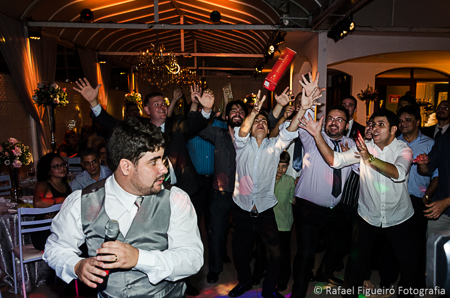 Convidados amigos e padrinhos disputam a garrafa de whisky Jonie Walker hilário fotografado por Rafael Figueiró fotógrafo melhor de casamentos em Recife-PE