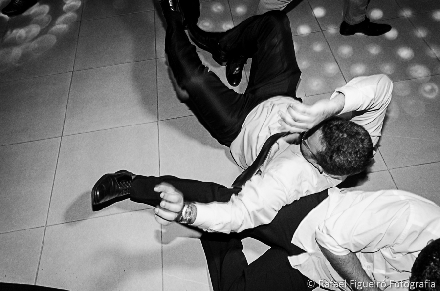 padrinho caindo no chão na tentativa de pegar a caixa de whisky lançada pelo noivo fotografado por Rafael Figueiró fotógrafo melhor de casamentos em Recife-PE