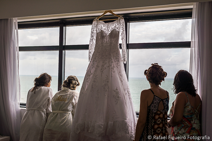 noiva e madrinhas admiram o mar pela janela fotografado por rafael figueiró melhor fotógrafo de casamentos em recife-pe