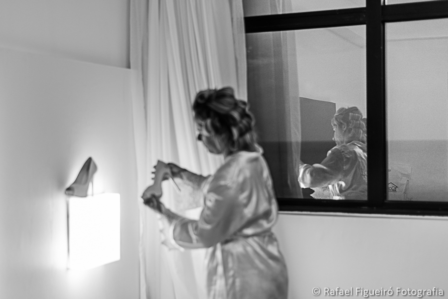 noiva admira seu sapato em baixa luz em reflexo do vidro na janela fotografado por rafael figueiró melhor fotógrafo de casamentos em recife