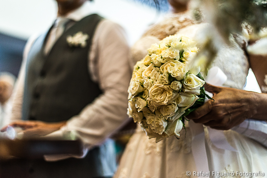 Detalhe do bouquet da noiva junto com o noivo no altar fotografado por Rafael Figueiró melhor fotógrafo de casamentos de Recife-PE